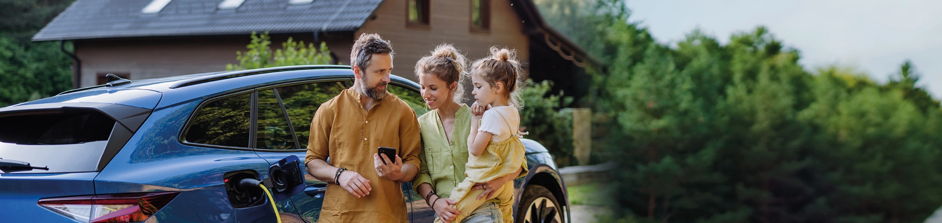 Familie mit Auto vor Einfamilienhaus mit Solardach