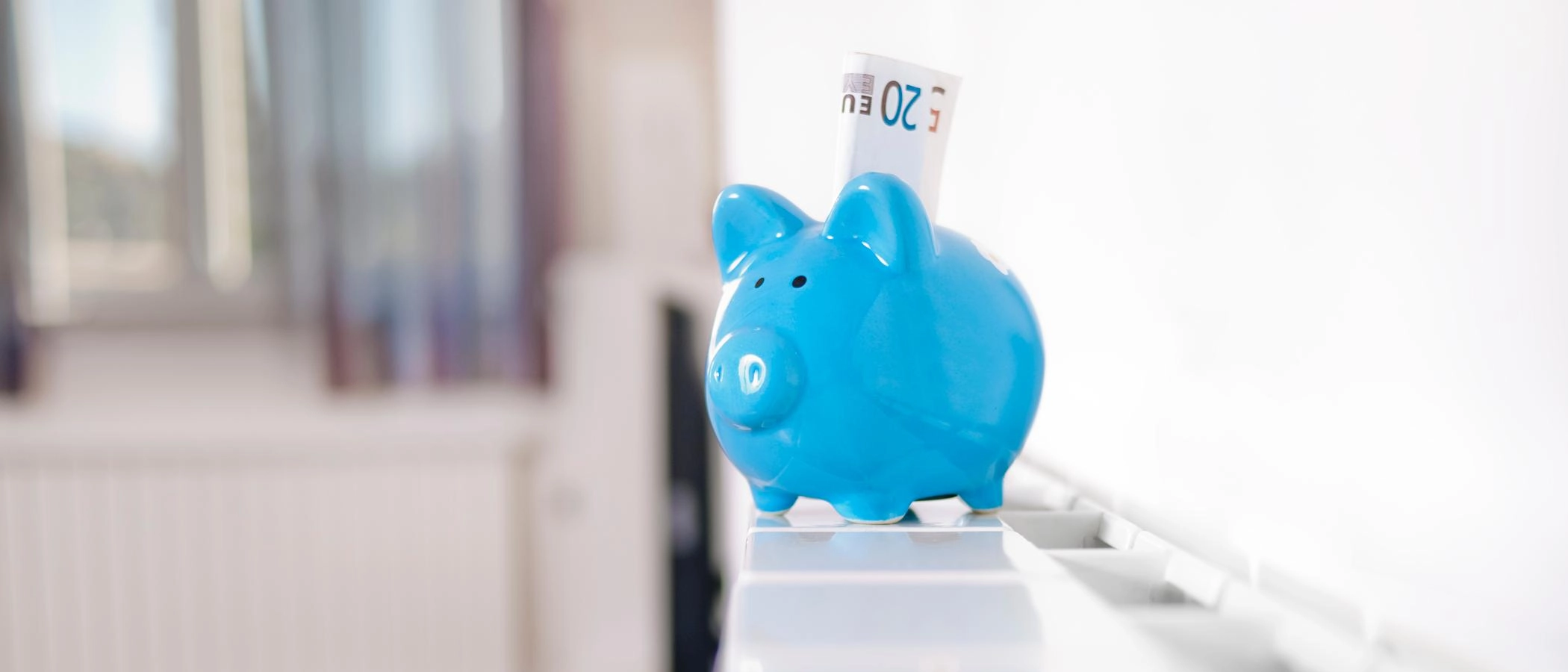 Ein Sparschwein steht auf einer Heizung