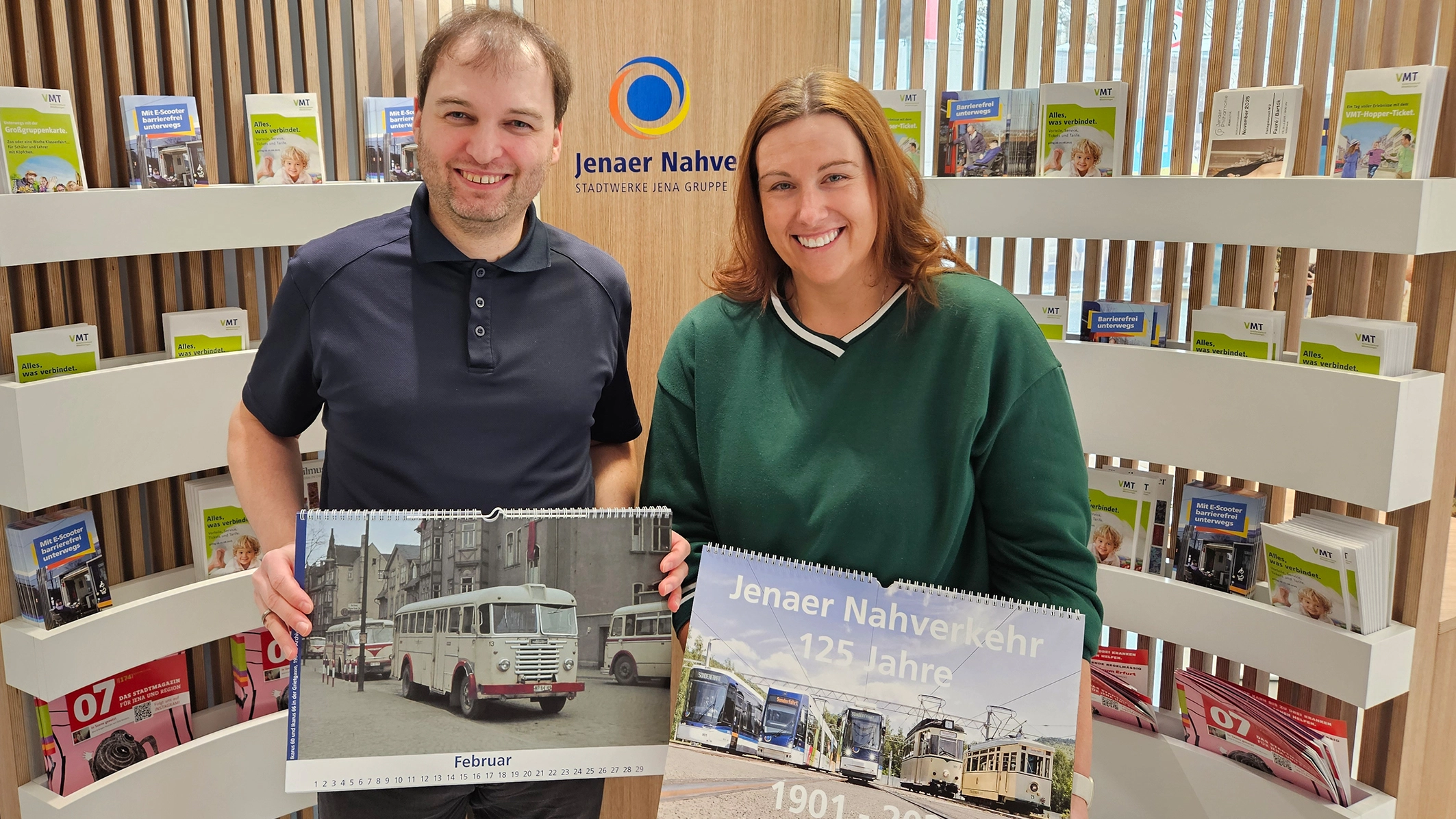 Peer Eismann und Stephanie Ebert vom Serviceteam des Jenaer Nahverkehrs präsentieren den Jubiläumskalender „125 Jahre Jenaer Nahverkehr“, der ab sofort im Stadtwerke Jena Kundencenter in der Saalstraße erhältlich ist. 