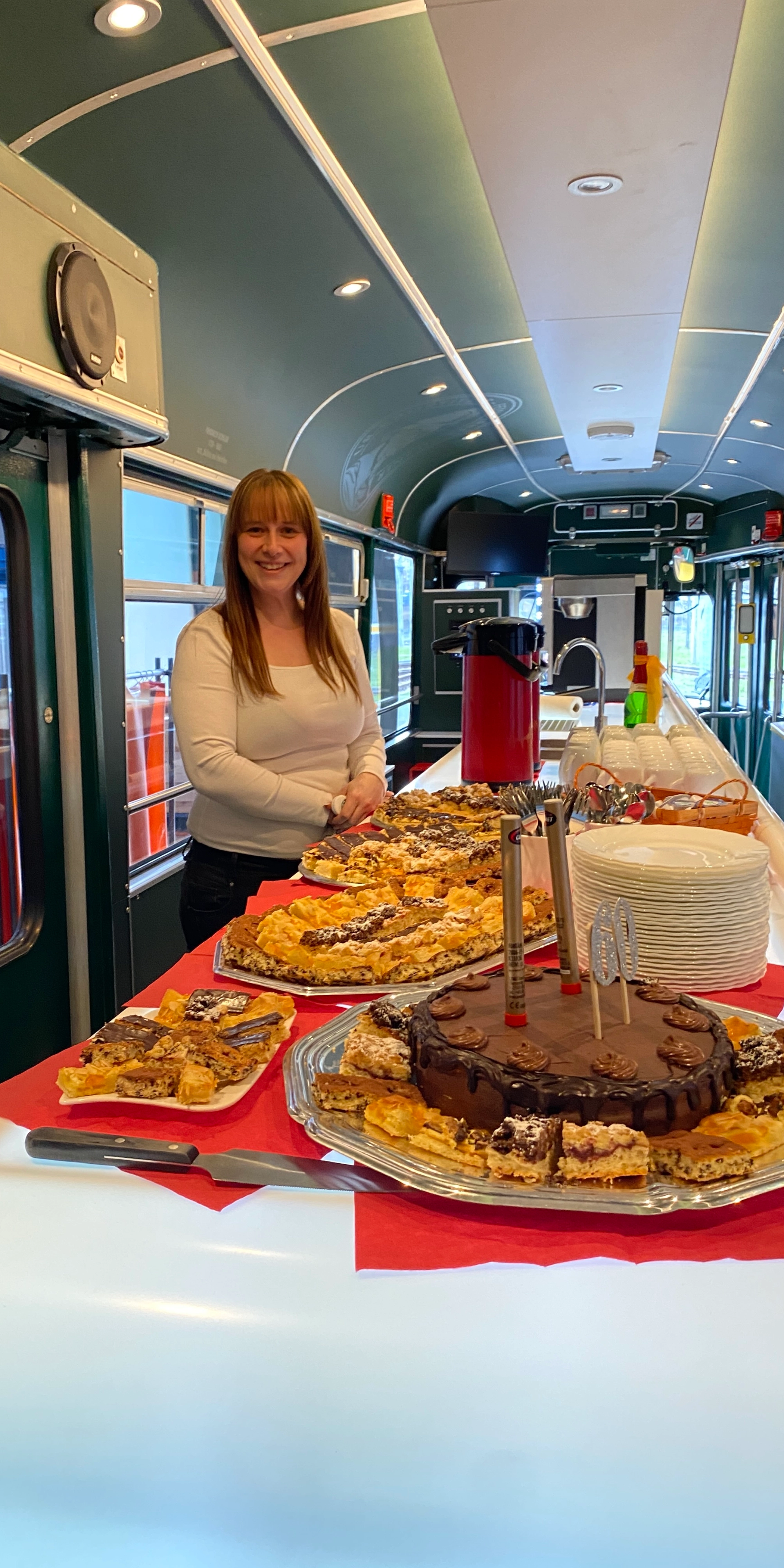Ein Kuchenbuffet auf dem Tresen in der Ur-Krostitzer Partybahn. Im Hintergrund ist eine Frau zu sehen.