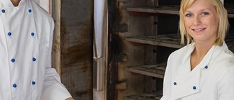 Zwei Bäcker halten ein Blech mit gebackenen Brötchen