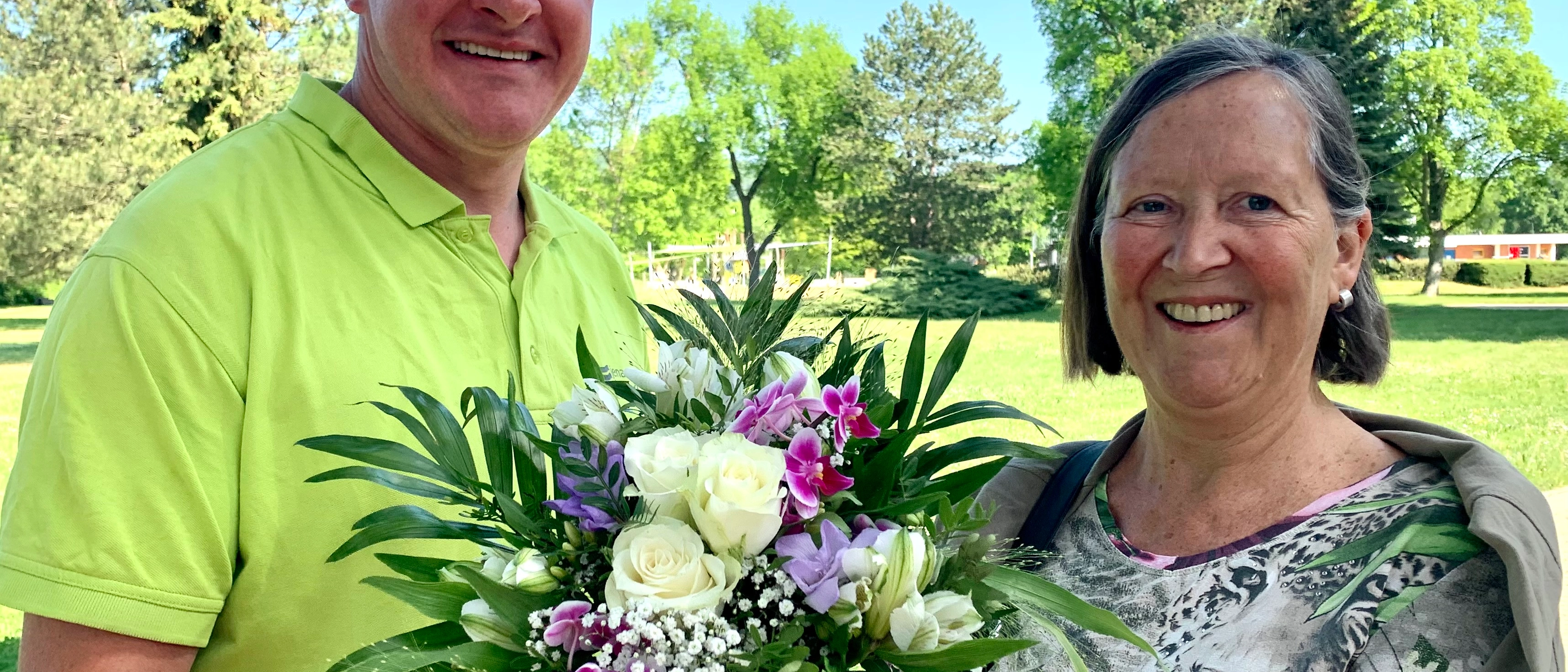 Zwei Personen halten einen Blumenstrauß in der Hand 