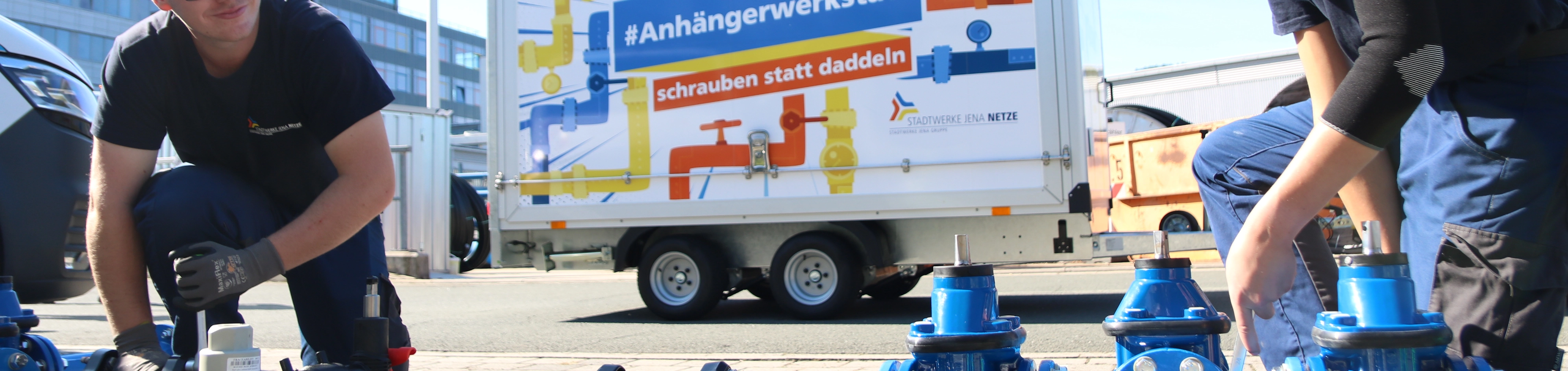 Zwei junge Männer präsentieren eine Anhängerwerkstatt. 