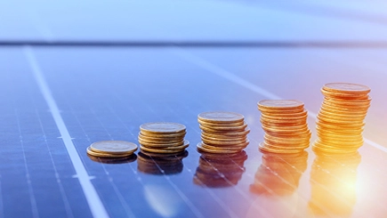 Münzen auf Solaranlagen symbolisieren Einsparpotentiale