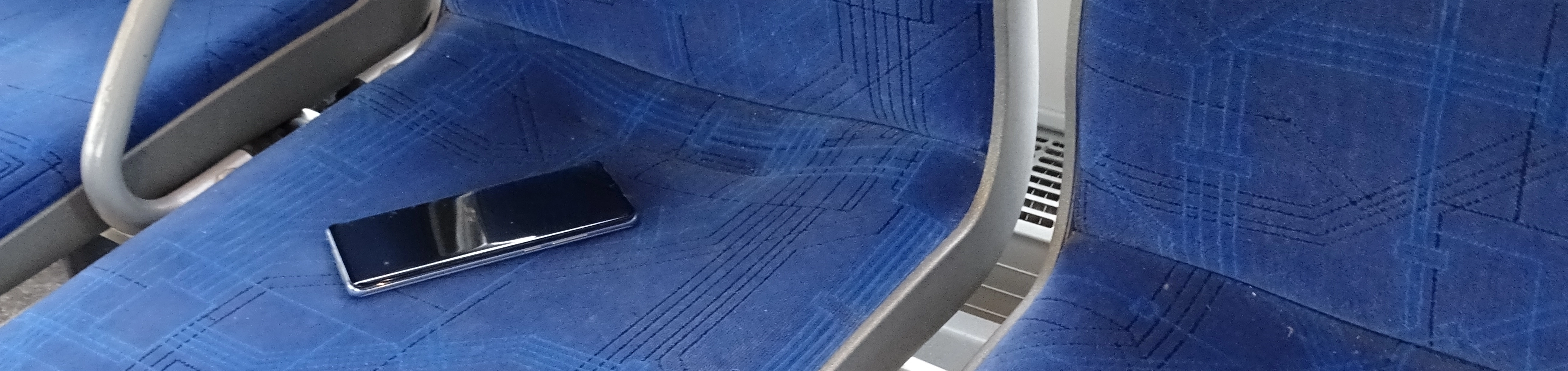 Ein Handy liegt auf einem Sitz in einem Bus.