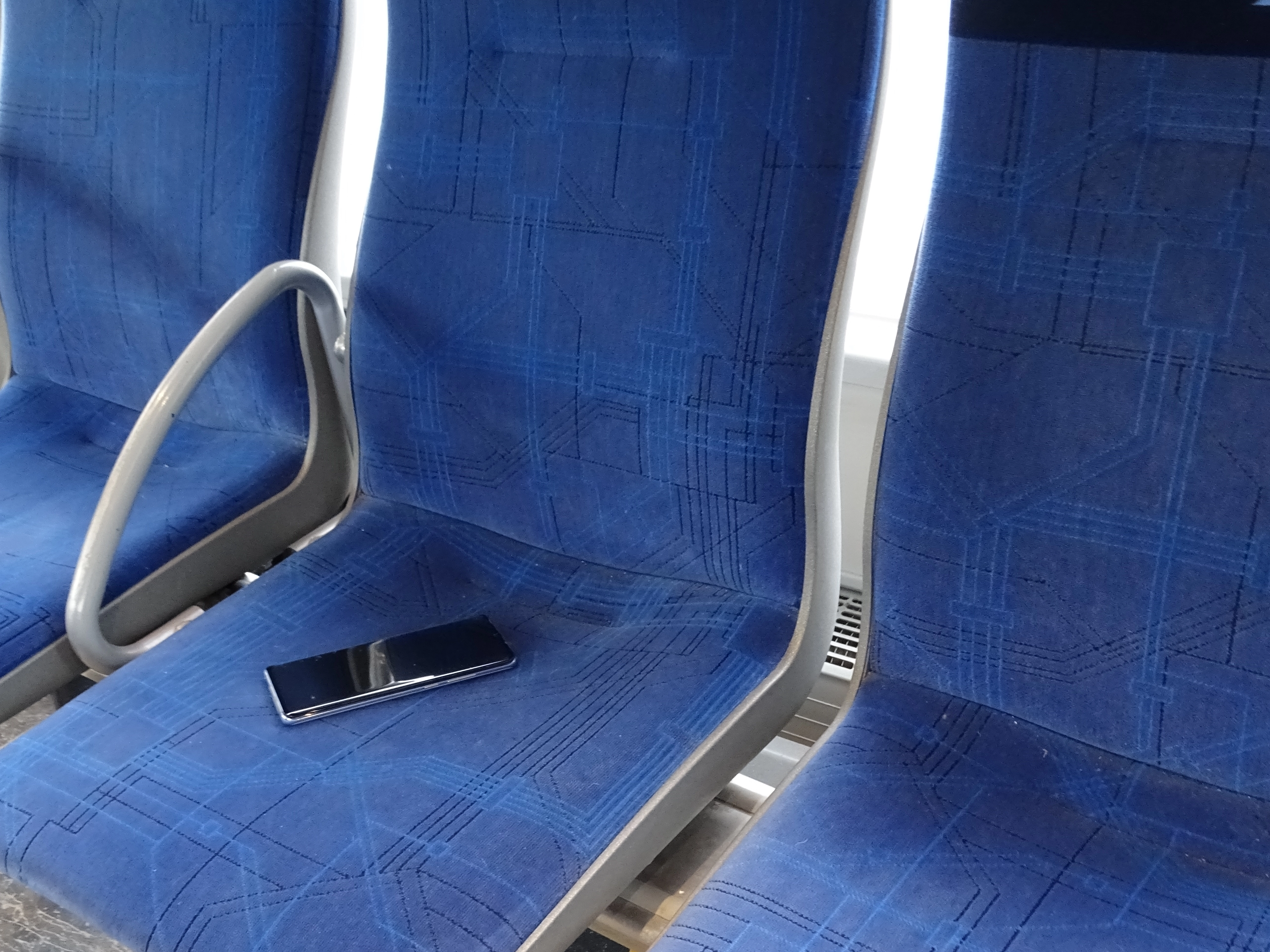 Ein Handy liegt auf einem Sitz in einem Bus.