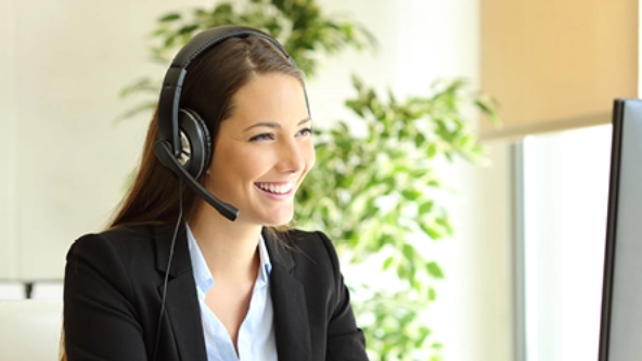 Eine Frau mit Headset sitzt an einem Computer