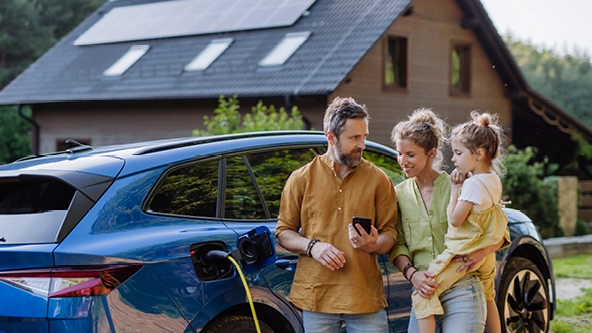 Ein Familie steht vor einem E-Auto, das geladen wird