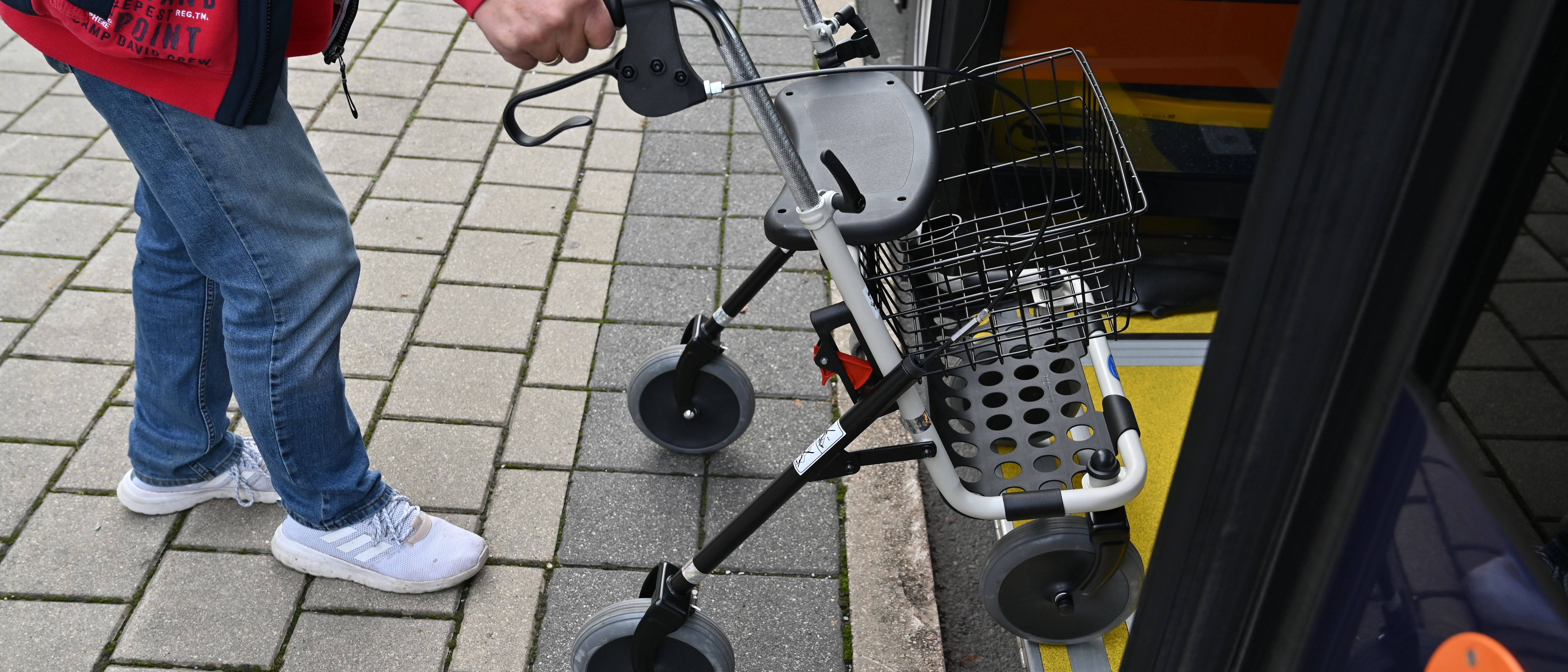 Eine Person steigt mit Rollator in den Bus.