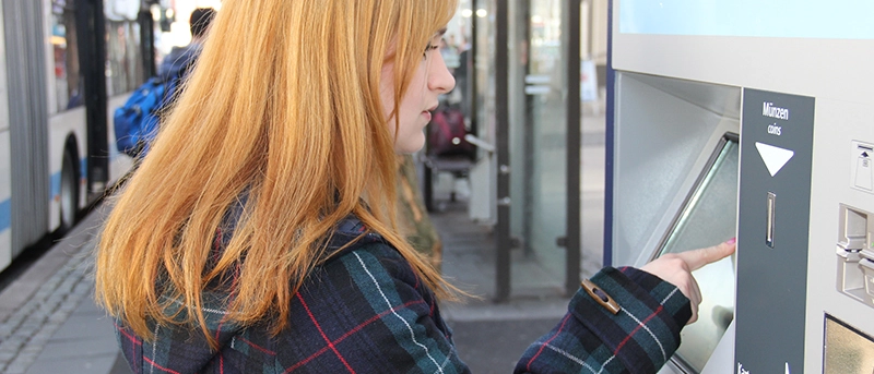 Eine Frau bedient einen Ticketautomaten