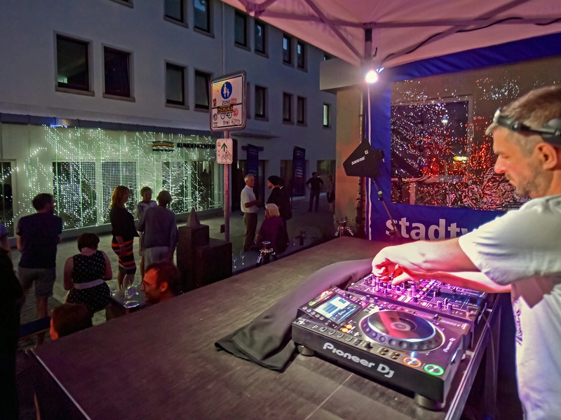 Ein DJ spielt zur Eröffnung vor dem Stadtwerke Jena Kundencenter 