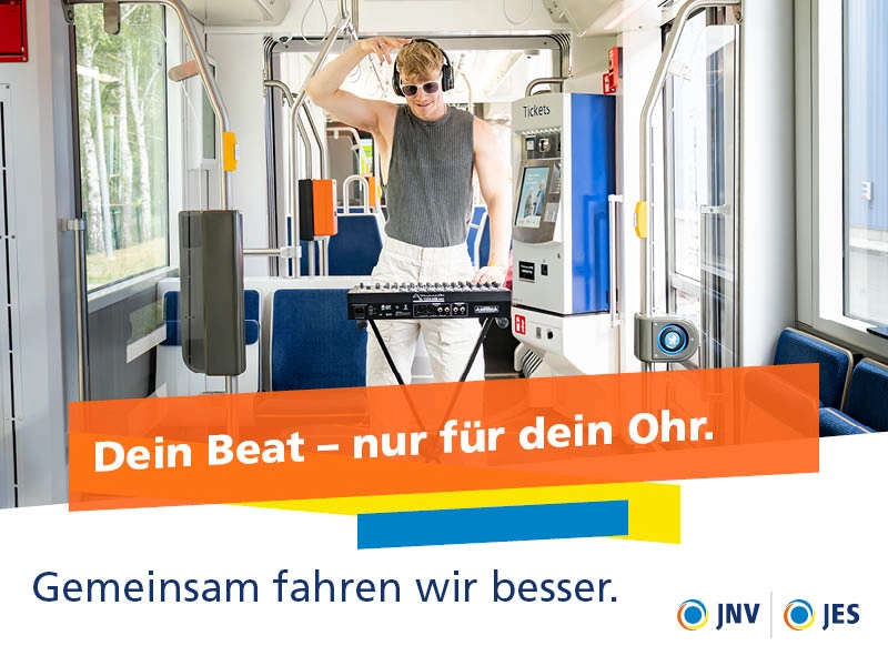 Ein Mann mit Kopfhörern steht an einem Mischpult in der Bahn.