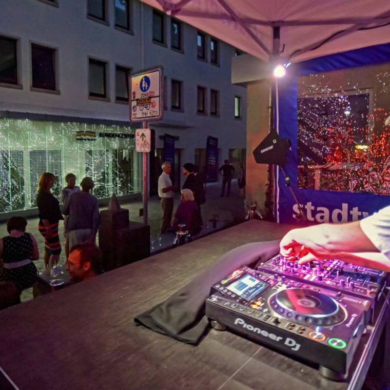 Ein DJ spielt zur Eröffnung vor dem Stadtwerke Jena Kundencenter 